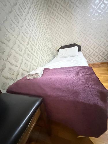 a bed with a purple blanket in a room at Sweet Baku Hostel in Baku