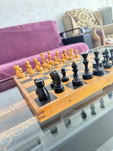 a wooden chessboard on a table in a living room at Sweet Baku Hostel in Baku
