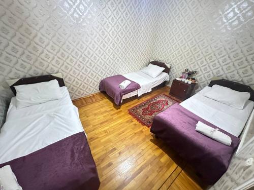 two beds in a room with wooden floors at Sweet Baku Hostel in Baku