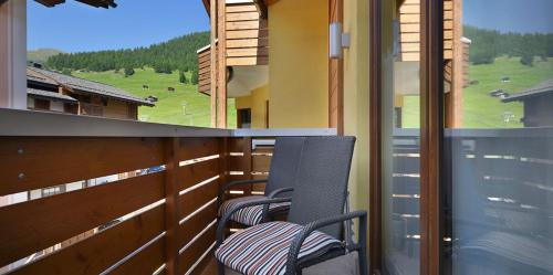 two chairs sitting on the balcony of a house at MOTA hotel in Livigno