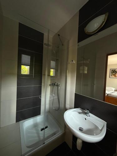 a bathroom with a shower and a sink and a shower at Pokoje Gościnne A i M Dendys in Korbielów