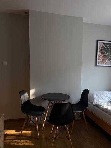 a room with a table and two chairs and a bed at Pokoje Gościnne A i M Dendys in Korbielów
