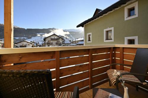 a balcony with chairs and a view of a snowy mountain at MOTA hotel in Livigno