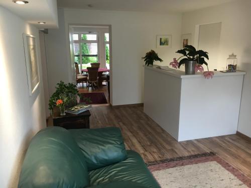a living room with a green couch and a counter at Landhaus Goldenes Kreuz in Leutkirch im Allgäu