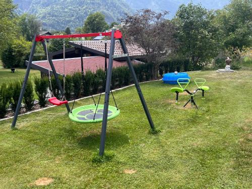 a swing set in the grass in a yard at Ferienhaus Feil in Oberdrauburg