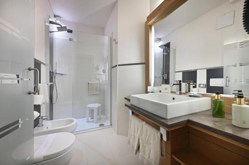 a white bathroom with a sink and a toilet at MOTA hotel in Livigno