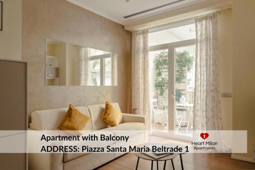 a living room with a couch and a mirror at Heart Milan Apartments San Sepolcro Duomo in Milan