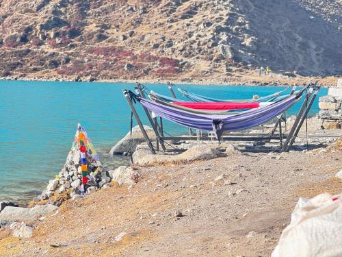 a hammock on a beach next to a body of water at Gokyo Thanka Inn in Khumjung