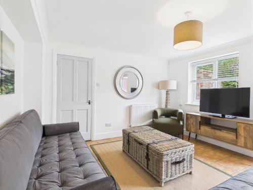 een woonkamer met een bank en een televisie bij Spacious Apartment with Private Garden in Norwich