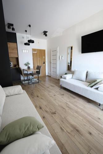 a living room with two white couches and a table at Apartament LUX in Zator