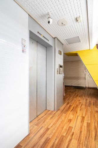 an empty room with a door and a wooden floor at Cozy Apartment, 2min to Station , Direct to Skytree, Asakusa & Ueno & Narita ,駅2分,スカイツリー浅草上野成田空港直結,エレベーター,スーパー2分,コンビニ1分 in Tokyo