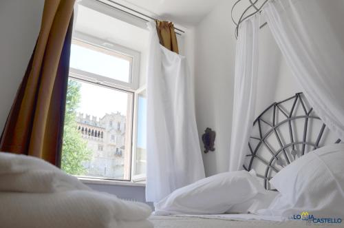 a white bedroom with a bed and a window at B&B La Loggia Del Castello in Trento