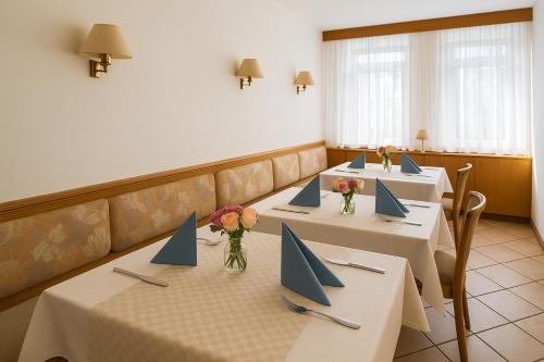 a row of tables in a restaurant with blue napkins at Goldene Gerste in Frankfurt/Main