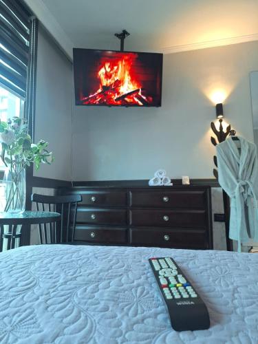 a bedroom with a bed with a tv on the wall at Hotel Asturias in Viña del Mar