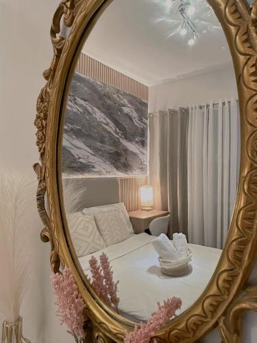 a mirror in a bedroom with a bed and a chair at Mesatierra Garden Residences in Davao City