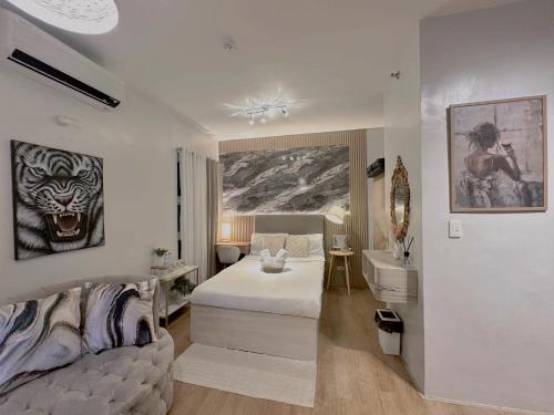 a bedroom with a bed and a couch and a sink at Mesatierra Garden Residences in Davao City