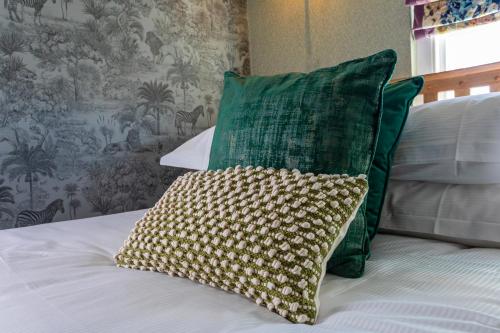 a green pillow sitting on top of a bed at Georgian House Hotel in Whitehaven