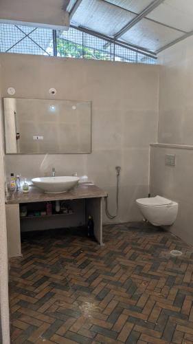 a bathroom with a sink and a toilet at Siridhama Farm 