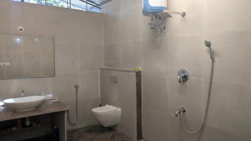 a bathroom with a shower and a toilet and a sink at Siridhama Farm 