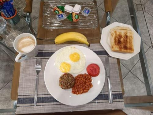a breakfast plate with eggs and beans and toast at Orchids Lodge in Fourways