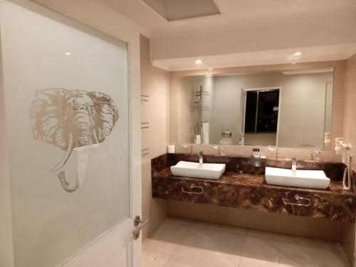a bathroom with two sinks and a large mirror at Orchids Lodge in Fourways
