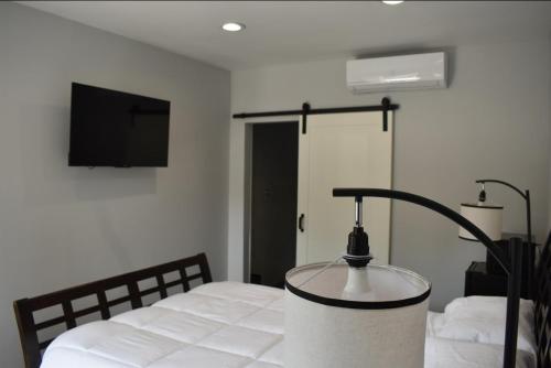 a bedroom with a bed with a lamp on it at Tannersville Village Rooms on Saw Mill Creek in Tannersville