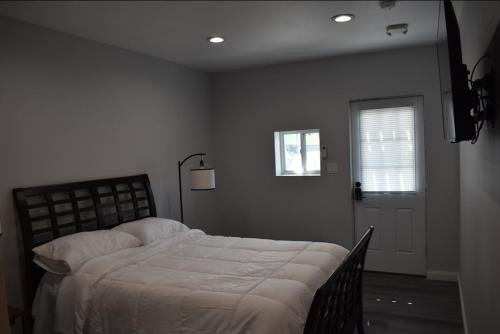 a bedroom with a bed and a window and a door at Tannersville Village Rooms on Saw Mill Creek in Tannersville