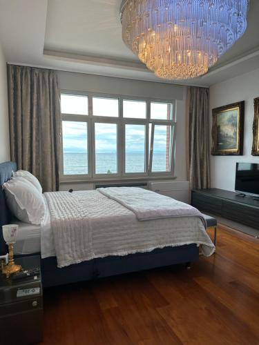 オパティヤにあるVilla Isabella - Luxury with style right next to the beach, private pool and sea viewの大きなベッドとシャンデリアのある寝室