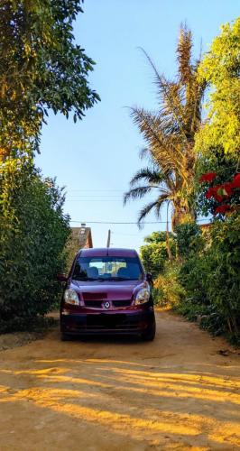 a purple car parked on a dirt road with trees at Charmante petite maison toute équipée in Talata-maty