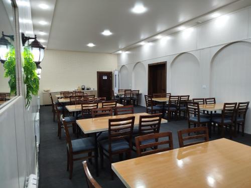 a dining room with wooden tables and chairs at Registon in Bukhara