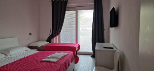 a hotel room with two beds and a window at Appartamenti a Bardolino in Bardolino