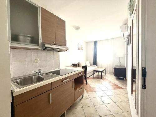 a kitchen with a sink and a living room at Hotel Priscapac Resort & Apartments in Prizba