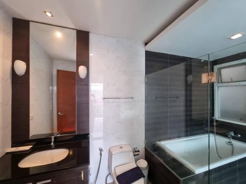 a bathroom with a tub and a sink and a bath tub at ChinJu PoolVilla in Jomtien Beach