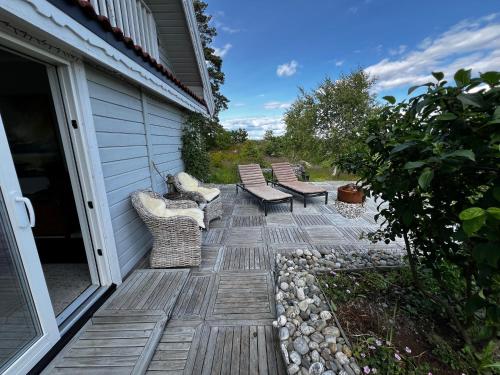 a patio with two chairs and benches on a house at Son view in Vestby