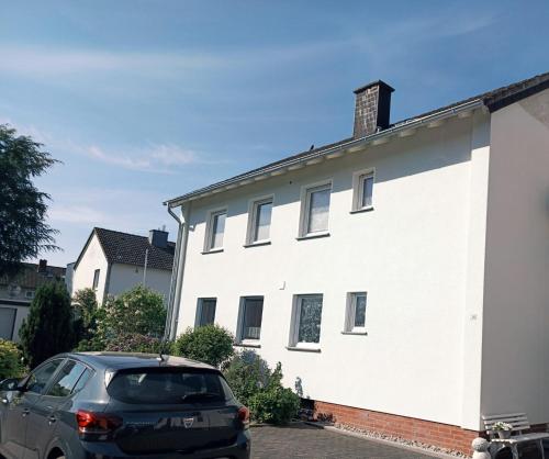 a car parked in front of a white building at Ferienwohnung Marita in Rietberg