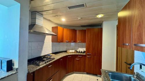 a kitchen with wooden cabinets and a stove top oven at Paramount Stay in Islamabad