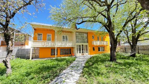 una casa de naranjos con árboles delante de ella en Art Villa Bakuriani, en Bakuriani