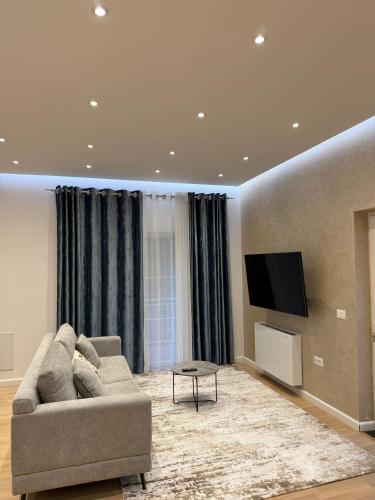 a living room with a couch and a flat screen tv at Bianca Hotel & Villa in Tirana