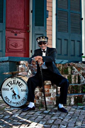 a man is sitting on a drum in front of a house at Creole Nest 3 b in New Orleans