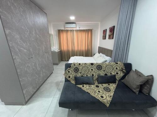 a bedroom with a bed and a couch in it at Apartamento em Foz do Iguaçu, Ravello Residencial in Foz do Iguaçu