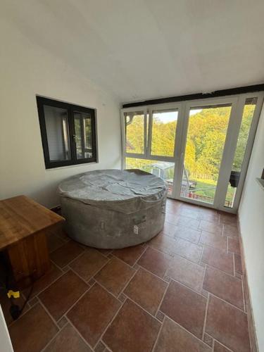 a room with a large tub sitting on a tile floor at Vuglovec House in Vuglovec