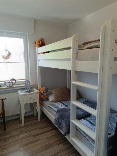 a bedroom with two bunk beds and a desk at Ferienwohnung Marita in Rietberg