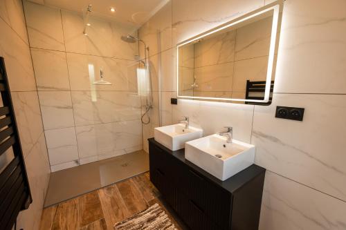 a bathroom with two sinks and a mirror at Chalet authentique - Au cœur des Quatre Lacs in Le Frasnois