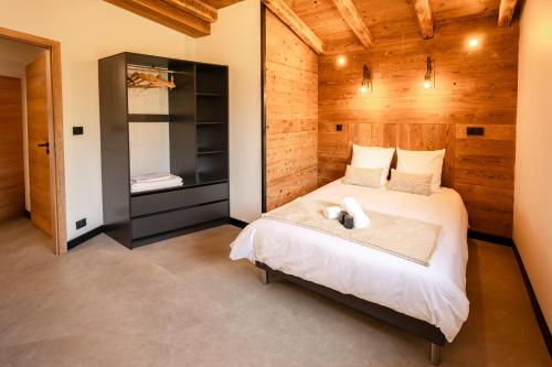 a bedroom with a bed in a wooden room at Chalet authentique - Au cœur des Quatre Lacs in Le Frasnois