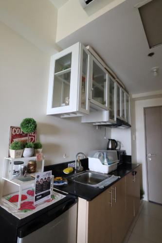 una cucina con mobili bianchi e un lavandino di Great Escape - Wind Residences a Kaybagal