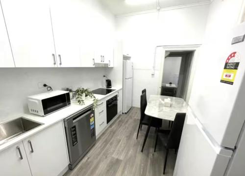 a small kitchen with a table and a microwave at FlexiRoom on Abercrombie in Sydney