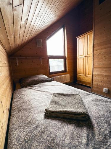 a bedroom with a bed in a cabin with a window at TEVA Lipno 131 in Lipno nad Vltavou