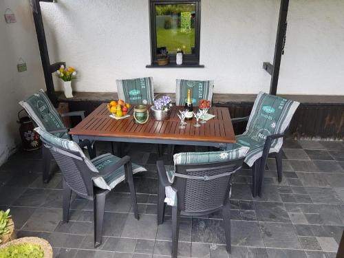 a wooden table and chairs with flowers on it at Rühlen Schneifel Escape in Auw