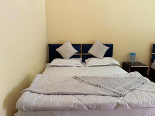a bed with two pillows on it in a room at AP Residency in Uttarkāshi