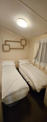 2 Betten in einem kleinen Zimmer mit Licht in der Unterkunft Large View 11 in Tattershall